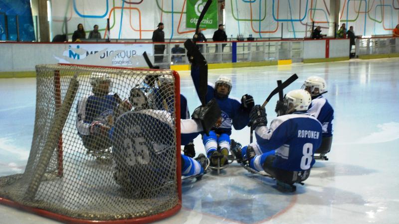 Finland's Para ice hockey team huddle in front of their goal