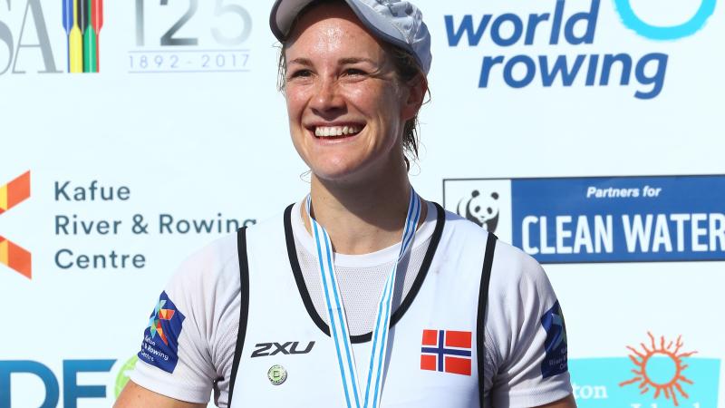 female Para rower Birgit Skarstein smiling with her medal on the podium