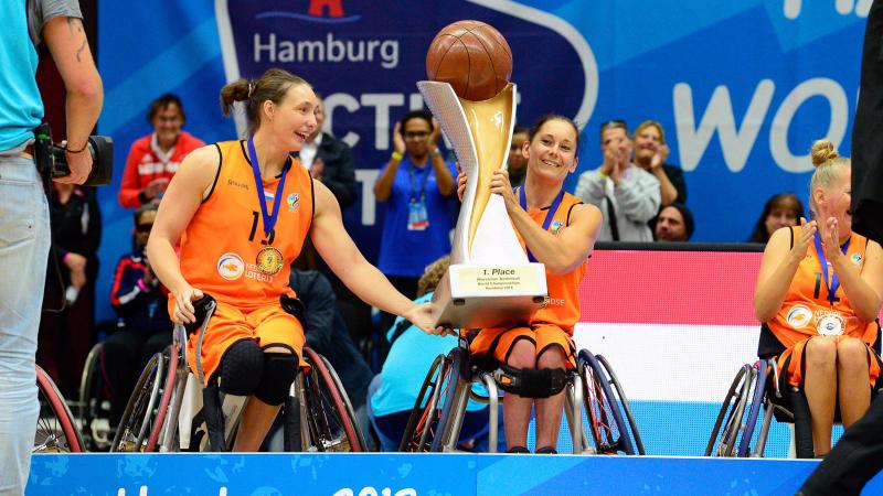 female wheelchair basketballer Carina de Rooij lifts up the trophy