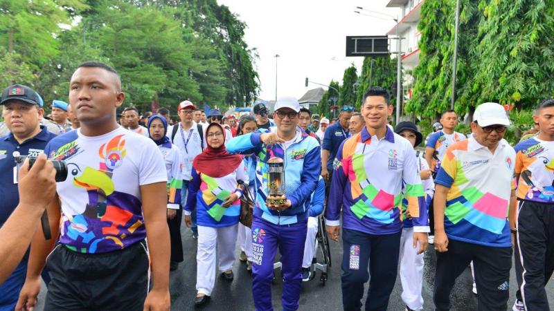 People marching together for a torch relay lighting ceremony