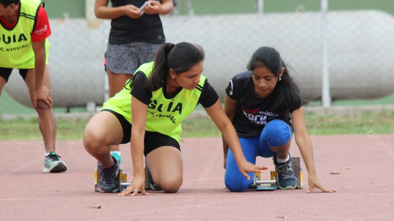 vision impaired runner competing on the track with her guide