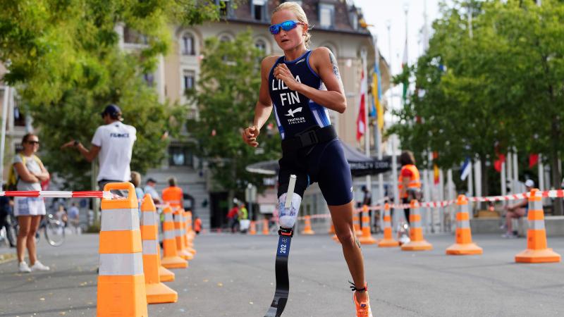 female Para triathlete Liisa Litja running round a corner on the road