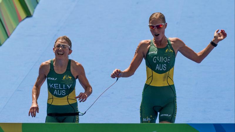 female Para triathlete Katie Kelly and female guide Michellie Jones break the finish tape