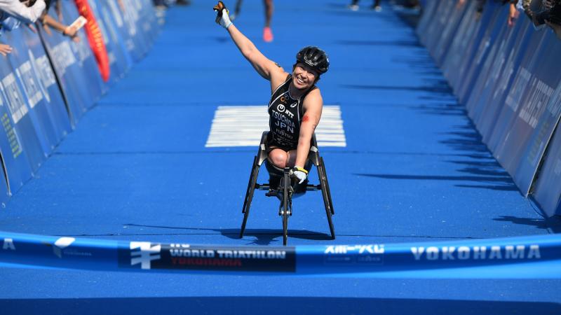 Japanese female Para triathlete Wakako Tsuchida punches the air as she crosses the finish line