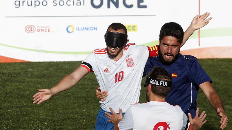 three male blind footballers including two from Spain battle for the ball