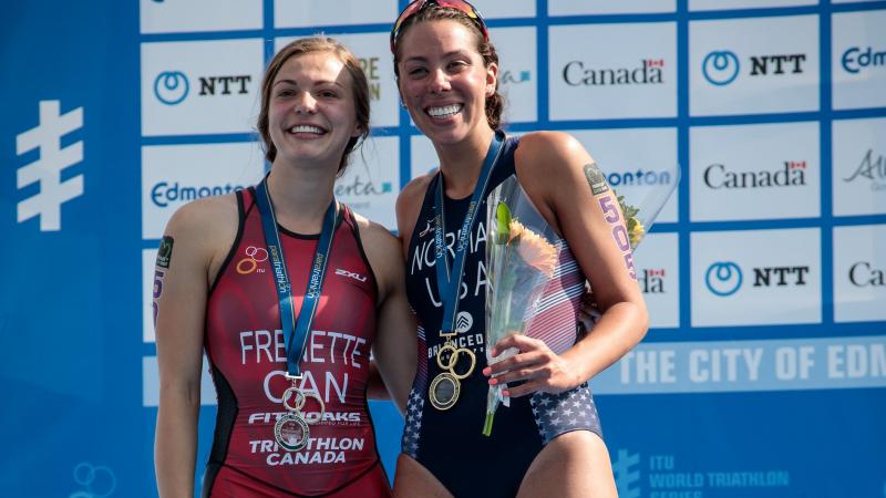 two female Para triathletes including Kamylle Frenette hugging on the podium