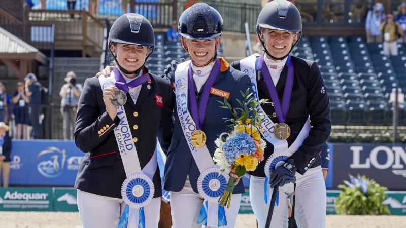 three female Para equestrian riders with Rixt van der Horst in the centre, standing on the podium