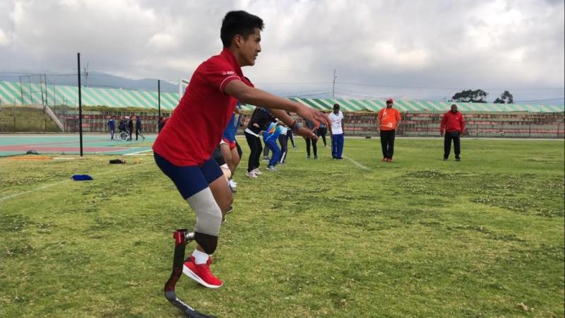 Man with prostethic leg standing on a football pitch