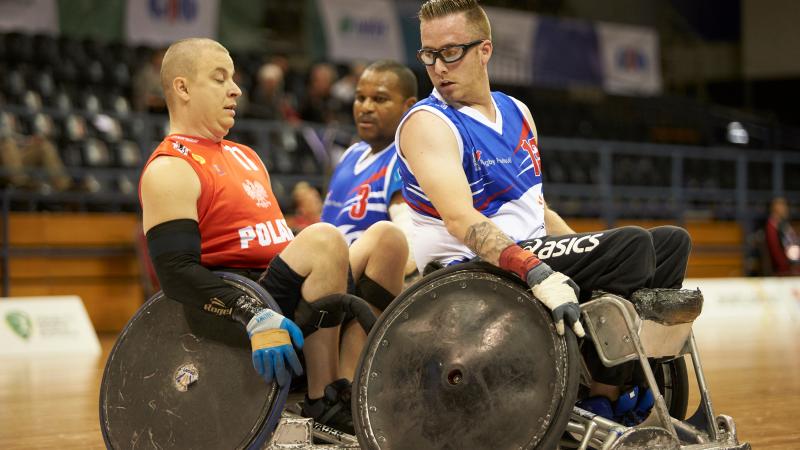 French and Polish wheelchair rugby players in action on the court