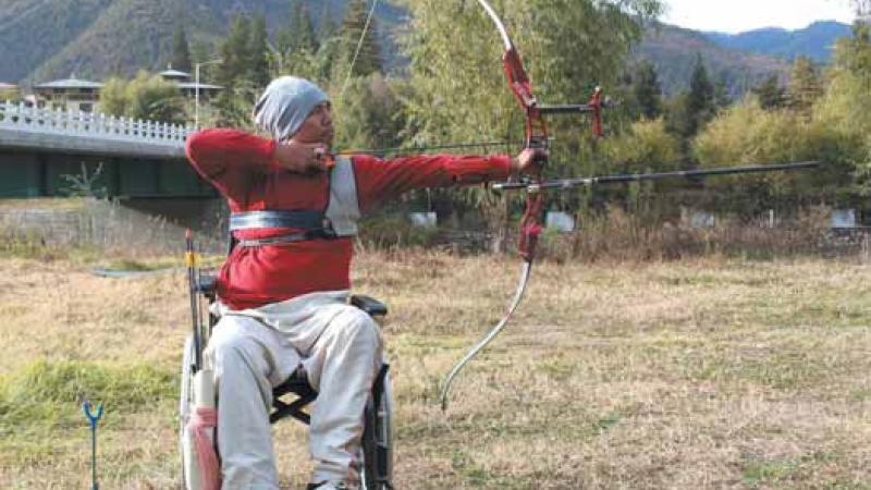 male Para archer Pema Rigsel prepares to shoot an arrow
