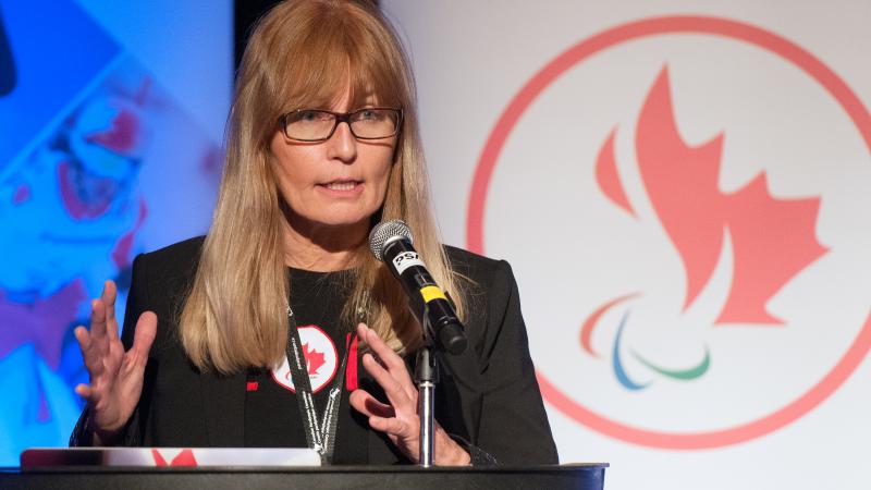 female chief executive Karen O’Neill speaking at a podium