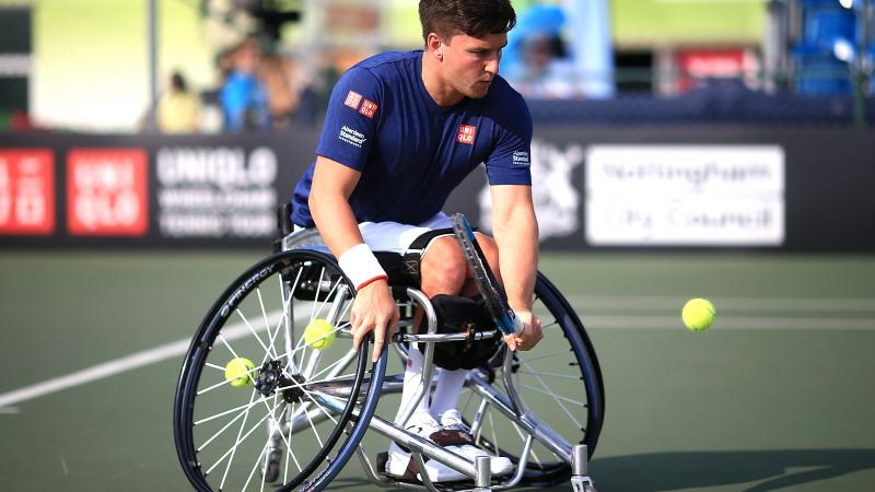 male wheelchair tennis player Gordon Reid plays a low backhand on a hard court