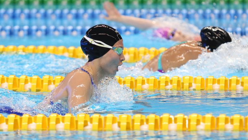 female Para swimmer Amilova Fotimakhon takes a breath during a breaststroke