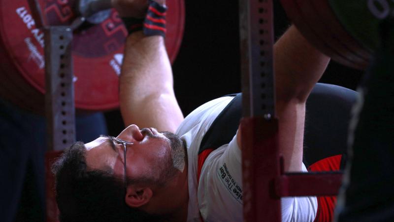 male powerlifter Roohallah Rostami gets ready to lift the bar