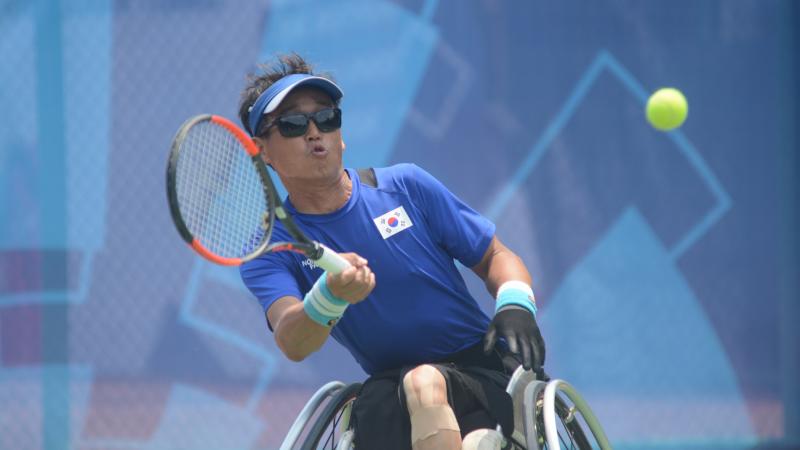 male wheelchair tennis player Kyu-Seung Kim plays a forehand