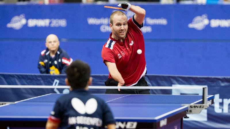 male Para table tennis player Peter Rosenmeier plays a forehand