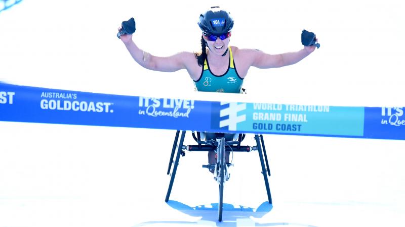 Australia woman in wheelchair raises arms before crossing finish line