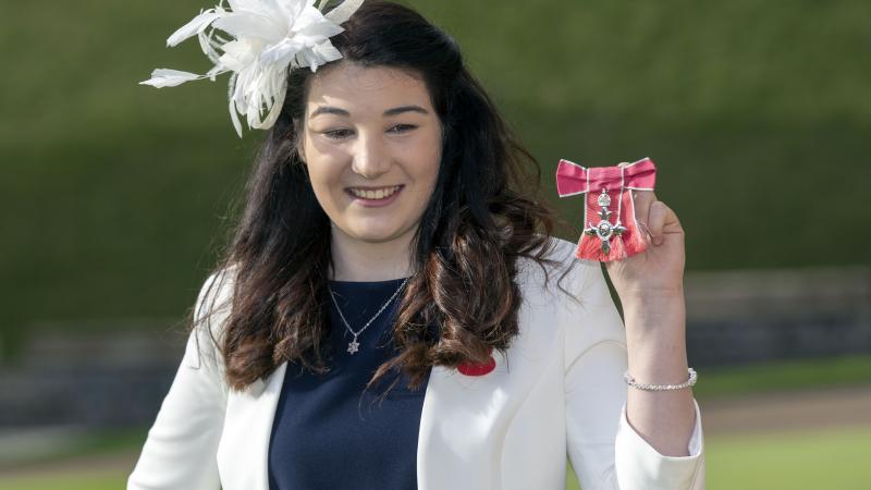 Female Para alpine skier Menna Fitzpatrick holding up her MBE medal