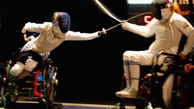 two female wheelchair fencers on the piste