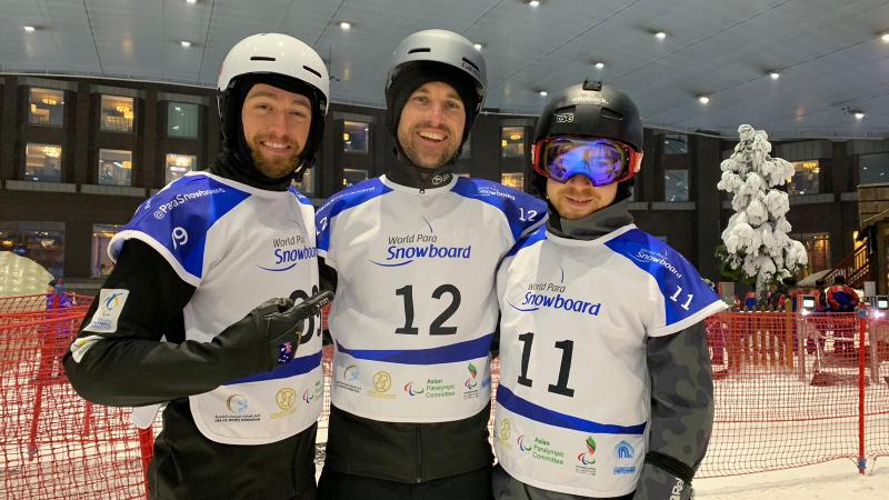 Three men with helmets in an indoor ski resort