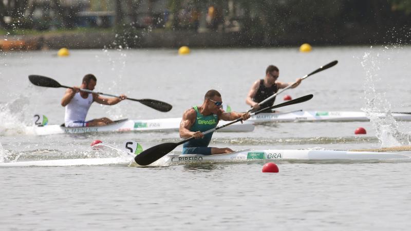 male Para canoeist Caio Carvalho mid-stroke during a race on the water