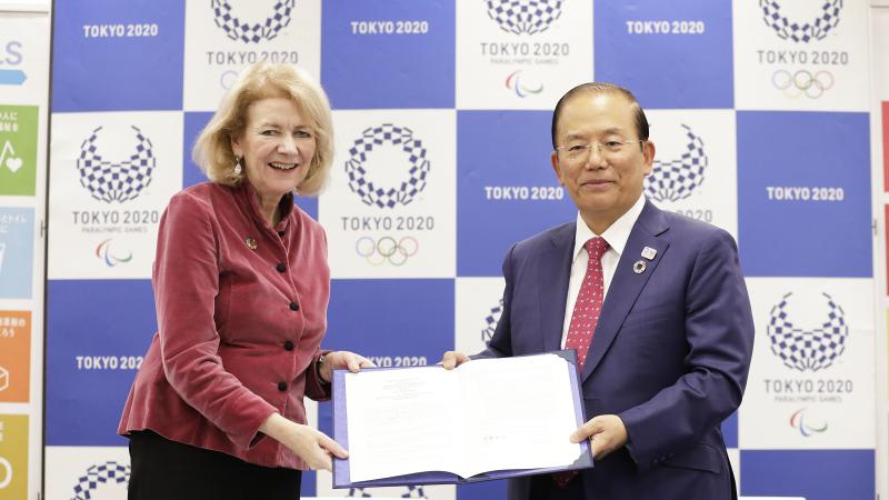 Tokyo 2020's Toshiro Muto and UN official holding a document together