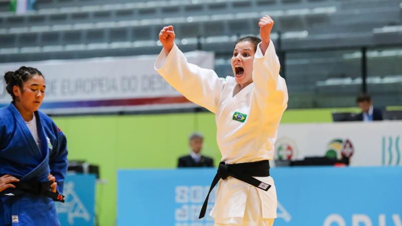 female judoka Alana Maldonado raises her arms to the ceiling in victory