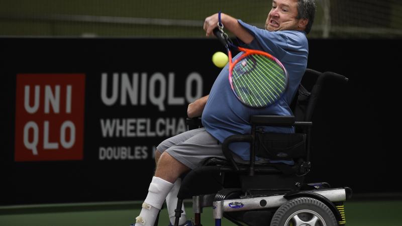 male wheelchair tennis player Nick Taylor plays a forehand on a hard court