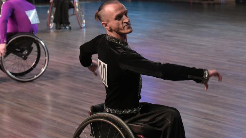 male Para dancer Ivan Sivak raises his arms in a wheelchair