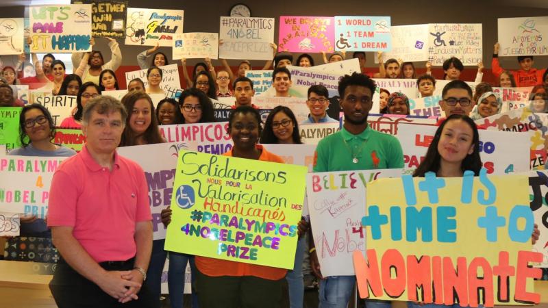 a group of students in a classroom holding up different coloured banners