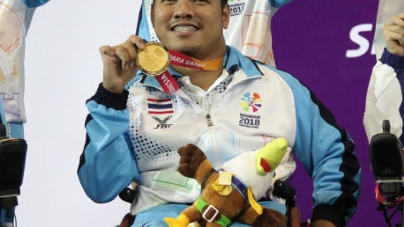 male boccia player Worawut Saengampa smiles and holds up his gold medal