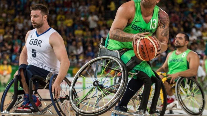 male wheelchair basketballer Leandro de Miranda shields the ball from another player