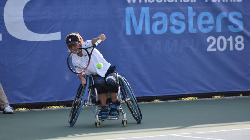 female wheelchair tennis player Yui Kamiji hits a backhand on a hard court