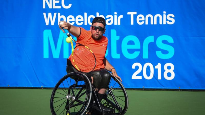 male wheelchair tennis player Dylan Alcott plays a backhand on a hard court