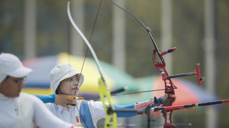 Chinese female archer pulls back her bow ready to shoot her arrow