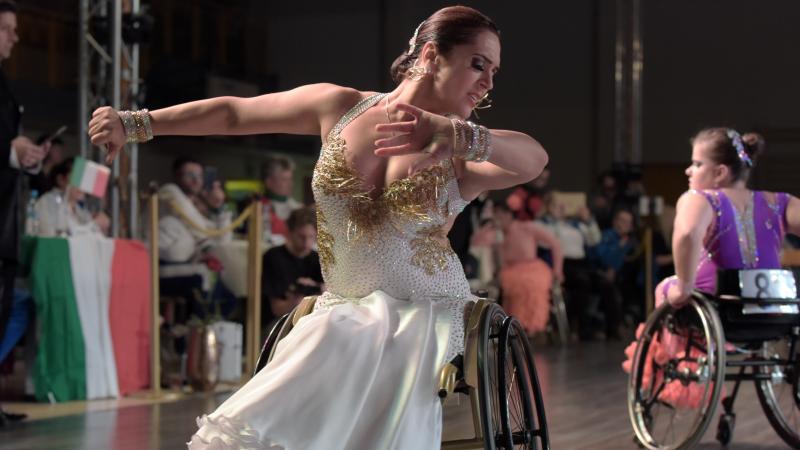 Ukrainian dancer in wheelchair wears glittering dress dances a conventional style