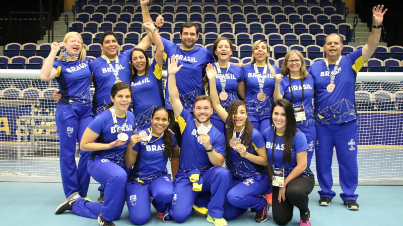 a group of female Brazilian goalballers smiling with medals round their necks