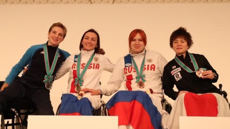 female wheelchair fencers Ludmila Vasileva and Beatrice Vio hugging on the podium