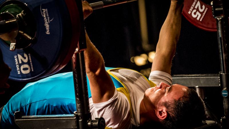 a male powerlifter from Kazakhstan on the bench