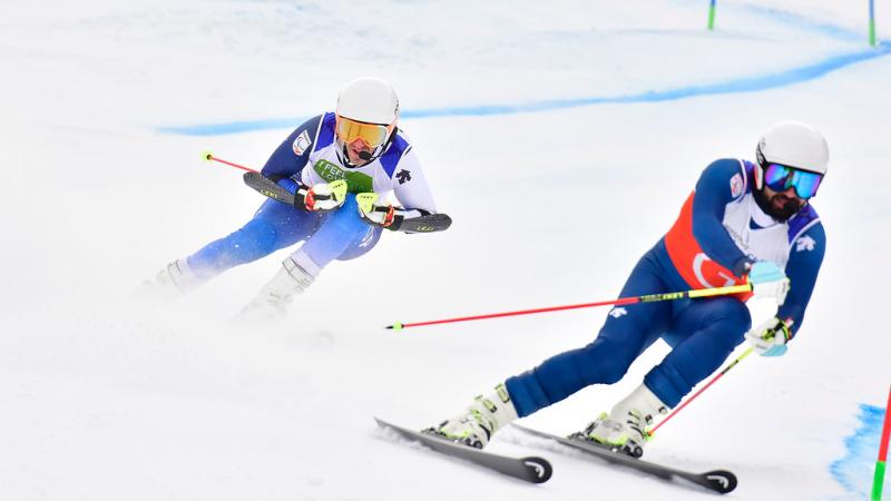 male vision impaired Para alpine skier Jon Santacana Maiztegui skies through a gate following his guide skier