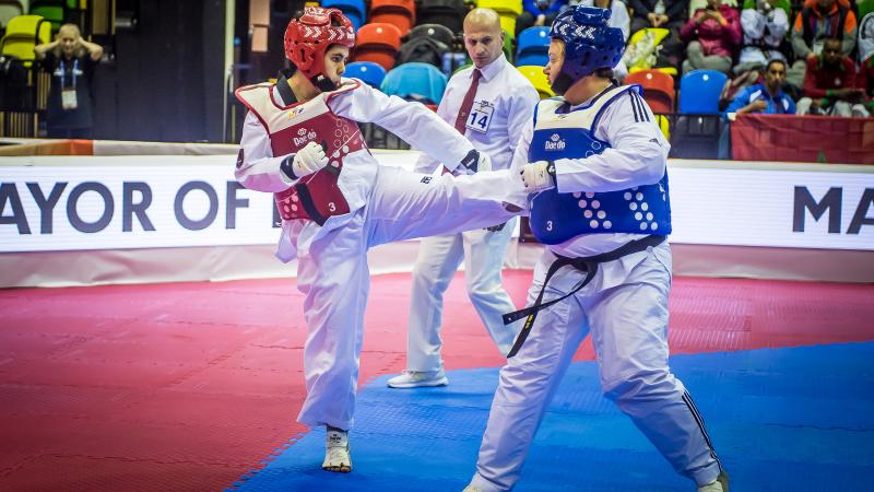 female Para taekwondo fighter Rajae Akermach kicks her opponent in the upper body