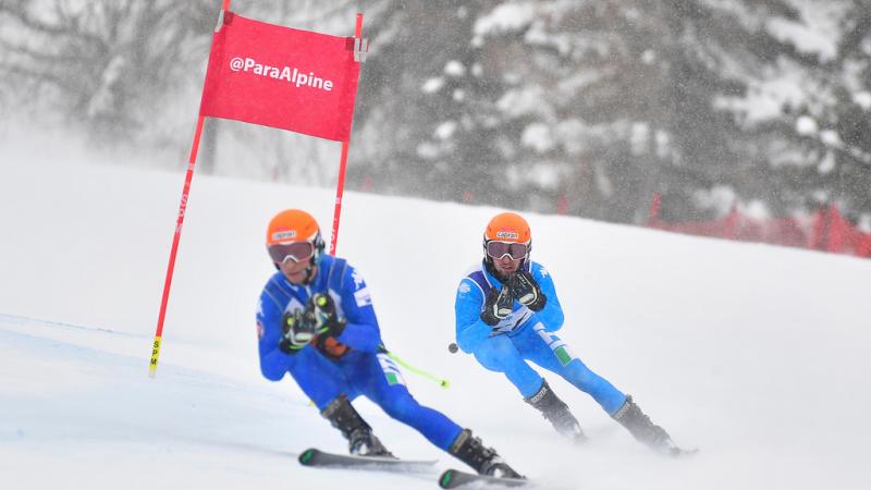 A vision impaired skier following his guide