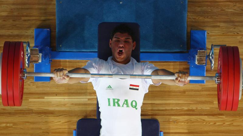 male powerlifter Rasool Mohsin yells as he lifts the bar