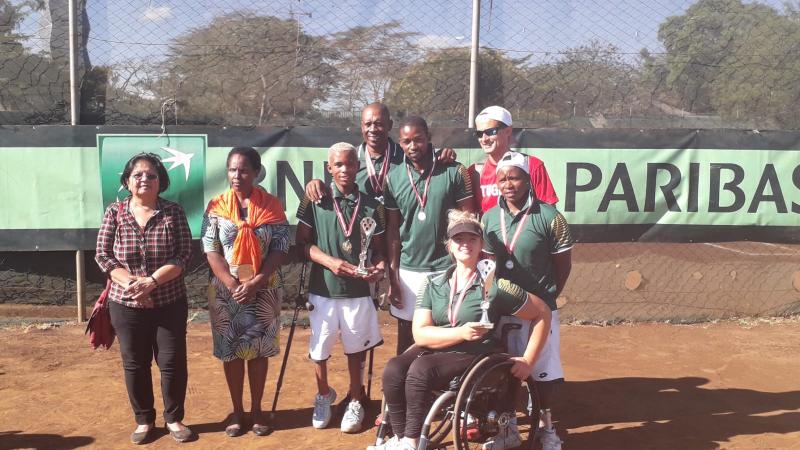 male and female wheelchair tennis players from South Africa hold up a trophy and smile