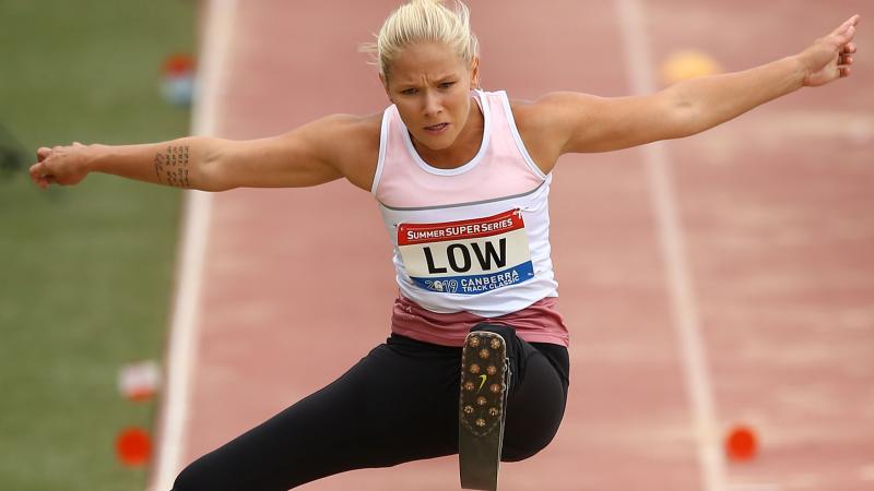 female Para athlete Vanessa Low jumps high above the long jump sandpit