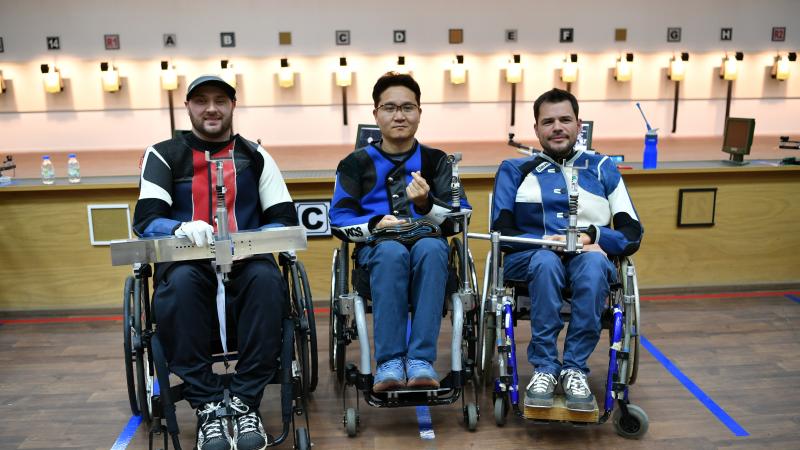 Three male shooters in wheelchairs