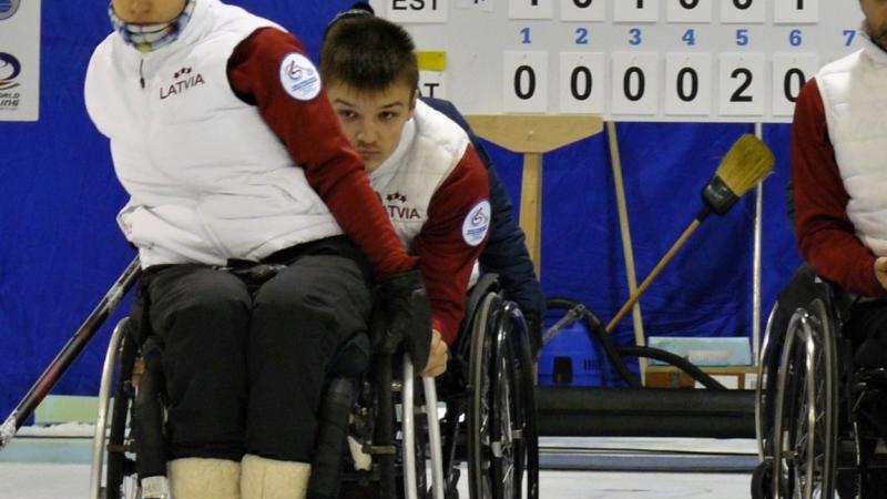 female wheelchair curler Polina Rozkova plays a stone