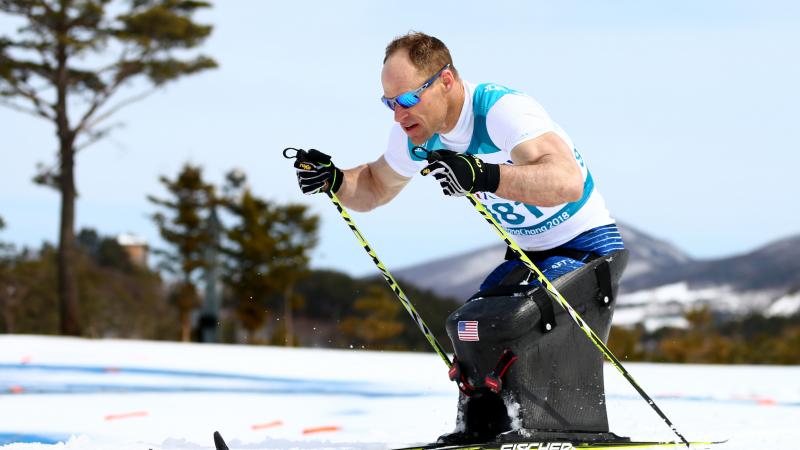 male Para Nordic sit skier Daniel Cnossen pushes through the snow