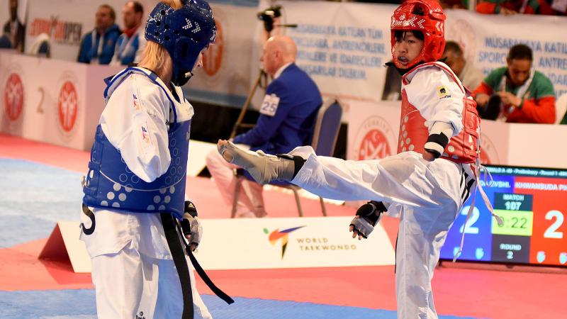 female Para taekwondo fighter Khwandusa Phuangkitcha kicks out towards another fighter