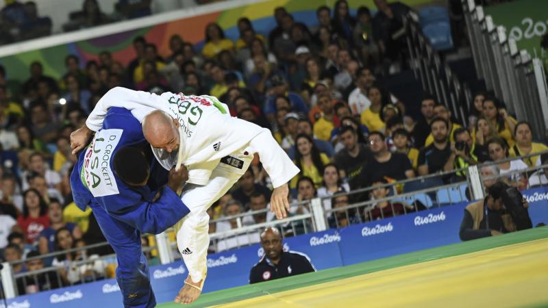 male Para judoka Sam Ingram throws another judoka onto the mat